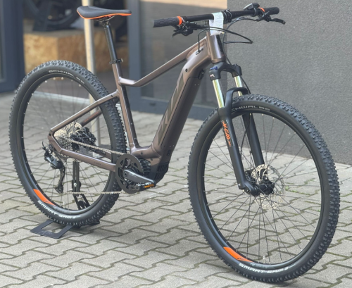 Rower KTM MACINA RACE Rozmiar XL w kolorze brązowo-złotym, ujęcie roweru stojącego na chodniku